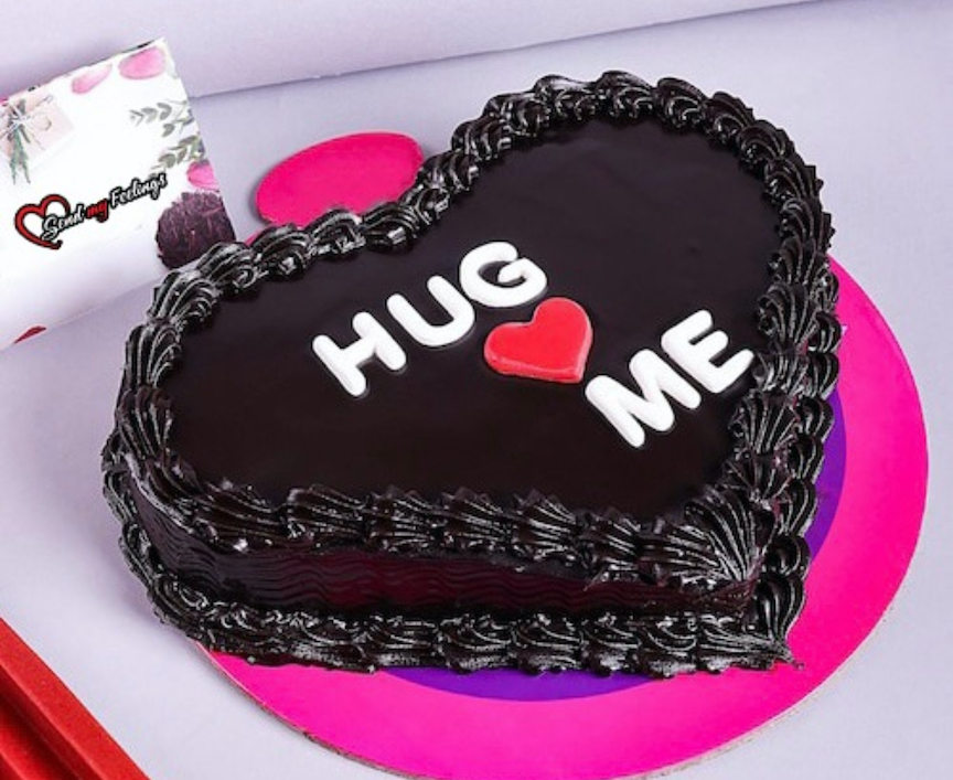 Heart shaped chocolate truffle cake with Hug Me message written on top, perfect romantic Valentine cake