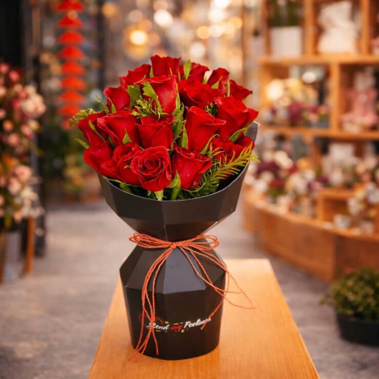 15 red roses wrapped in black collapsible packing for romantic gifting
