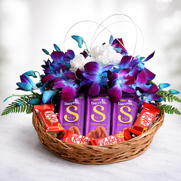 Orchid Royale Treat Basket with blue orchids, white carnations, and assorted chocolates